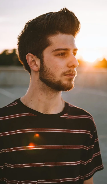 Man with Bono Hair system at sunset