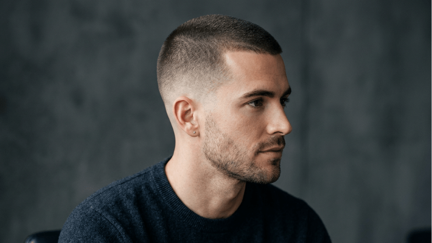 A man modeling a classic ultra-short buzz cut hairstyle.