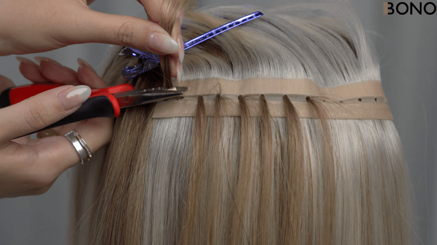 A stylist installing Bono Hair‘’s Butterfly Weft hair extension