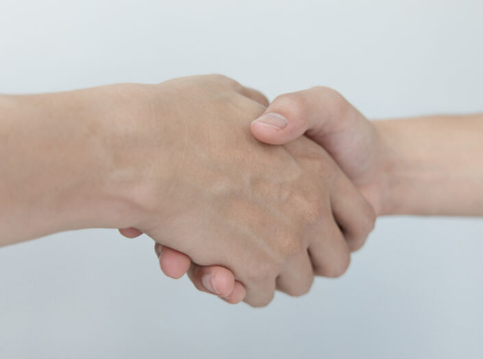 Two hands shaking in partnership: Bono Hair supports new hair replacement business owners